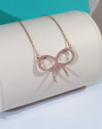 CLAW SET RHODIUM PLATED BOW NECKLACE
